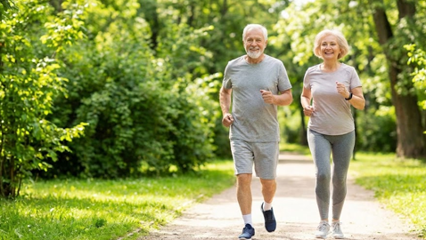 공원에서 활기차게 조깅하며 환하게 웃고 있는 건강한 노부부의 모습
